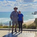 Scenic coastal walk along the Great Ocean Road with two hikers enjoying ocean views and limestone fo.