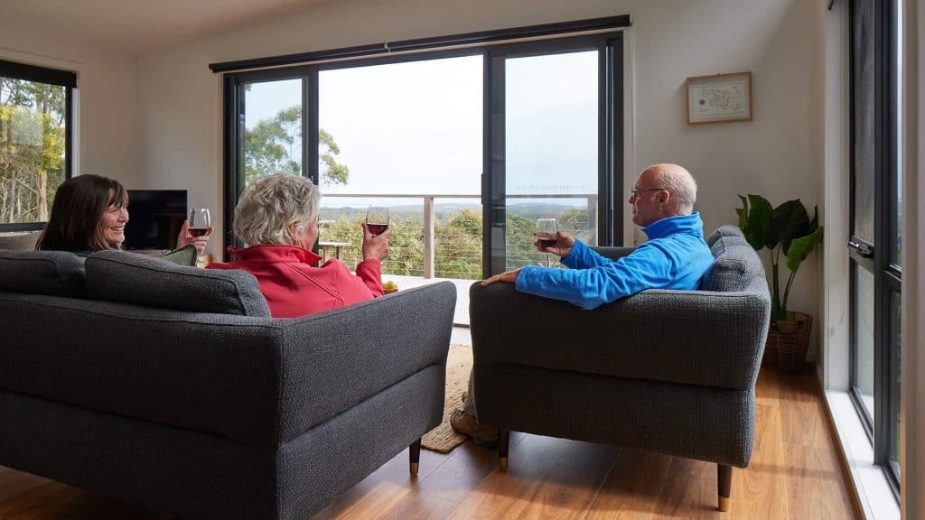 Enjoying a relaxing drink together in a modern living room with large windows and scenic views.