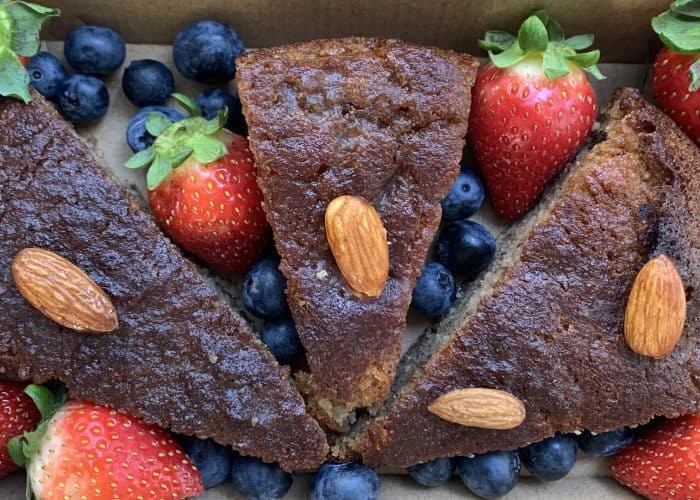 Dark chocolate almond bark with fresh strawberries and blueberries, close-up.