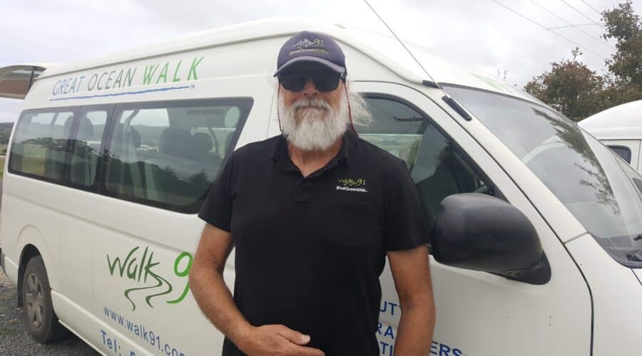 Walk 91: Personalised Ocean Walk Experience A Walk91 team member with a white beard and sunglasses stands in front of a van labeled "Great Ocean Walk" and "Walk 91," ready to explore the differences between the Mild Side and the Wild Side of The Great Ocean Walk.